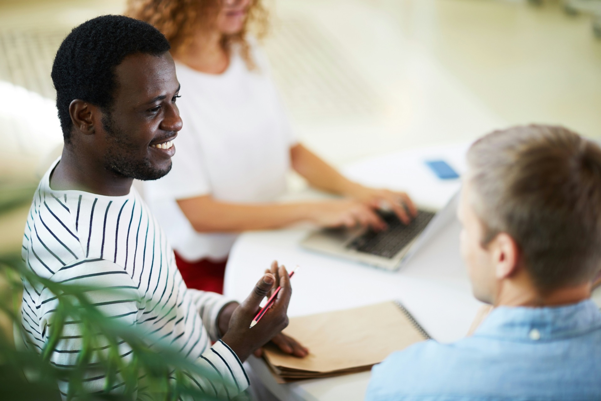 Drie collega's in gesprek aan een tafel op kantoor