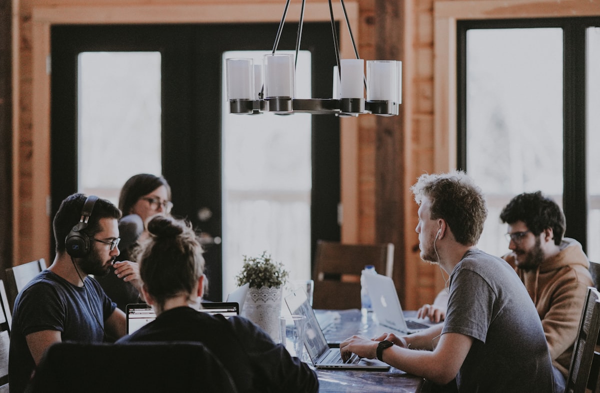 Collega's overleggen aan tafel met laptops